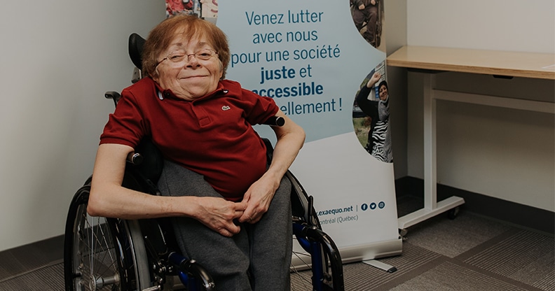 Femme en chaise roulante devant une affiche de l'organisme  Ex eaquo